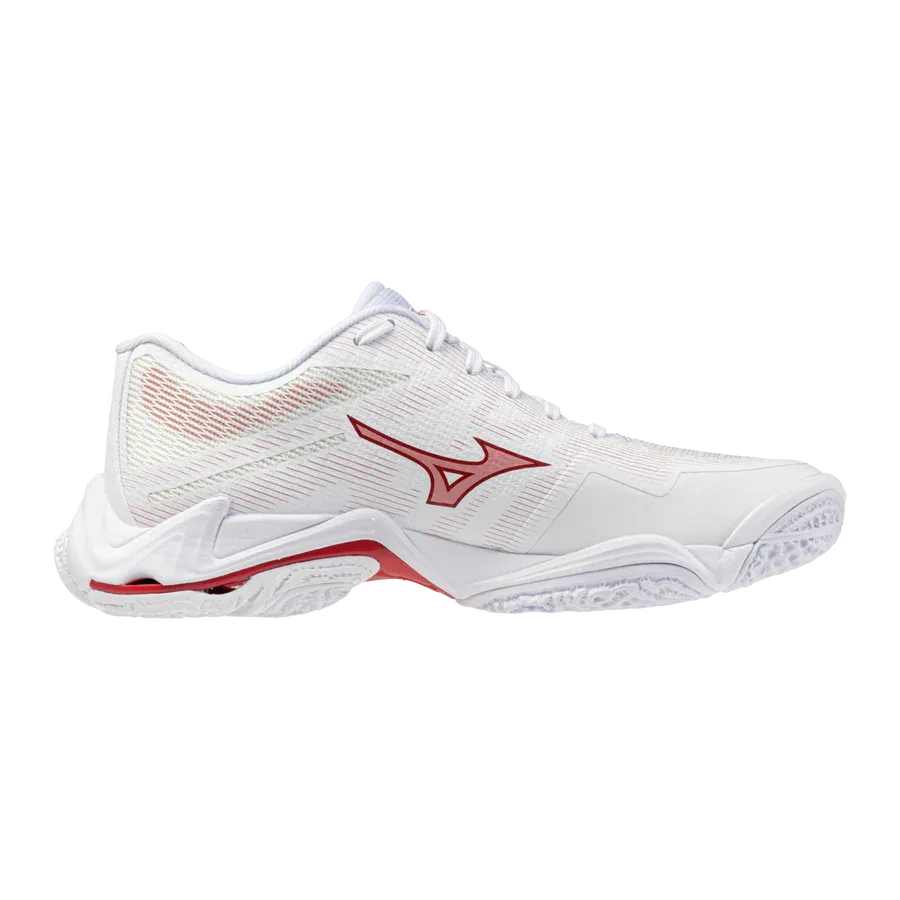 ה-Mizuno WAVE LIGHTNING ELITE(W) V1GC260073 הוא נעל ספורט לבנה עם נגיעות אדומות, חלק עליון מרשת וסוליה מרקמת, המוצגת מהצד על רקע לבן חלק.