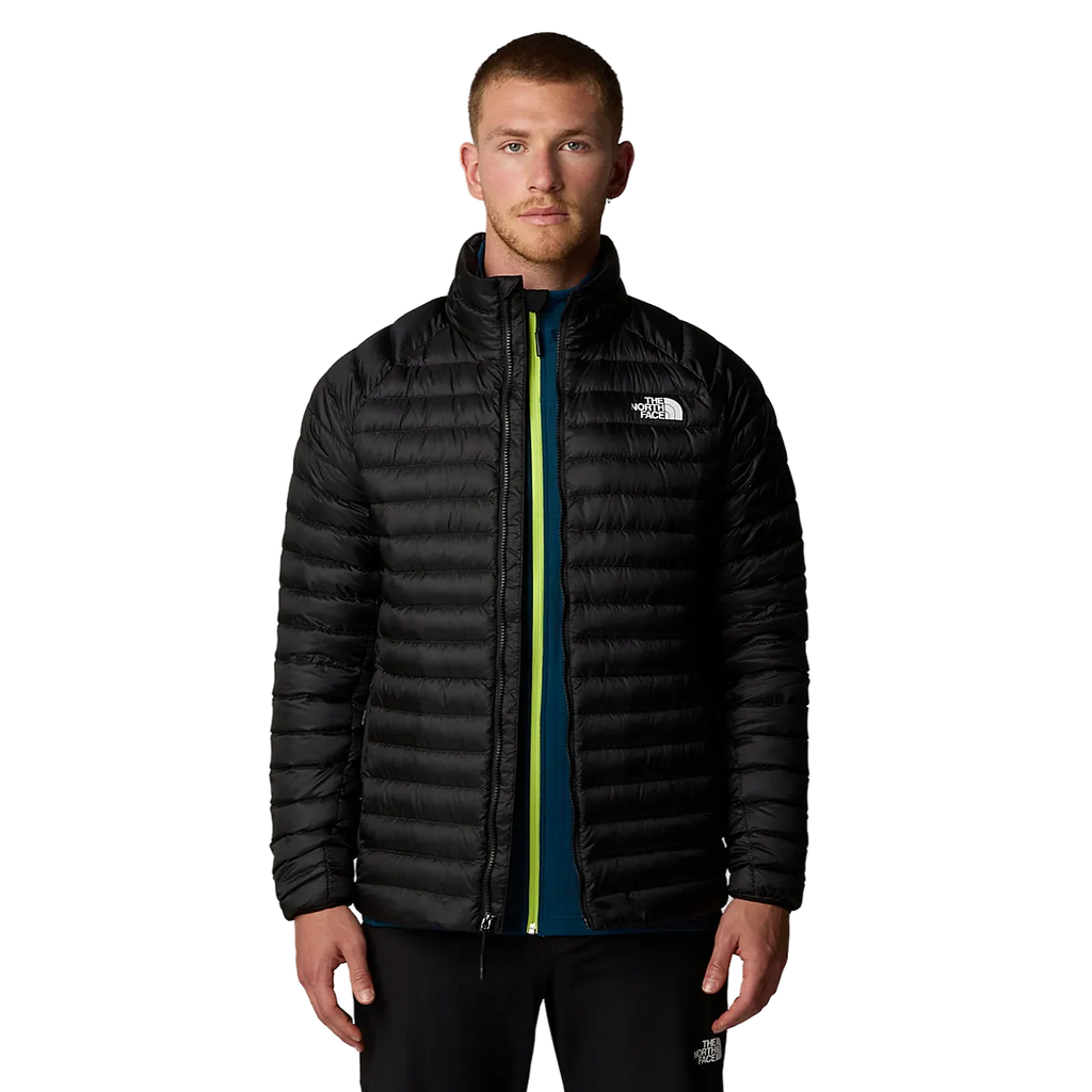 גבר עומד עם הפנים קדימה, לבוש במעיל The North Face BETTAFORCA LT DOWN ג'קט פוך לגברים מעל חולצה בצבע טורקיז עם רוכסן צהוב, על רקע לבן חלק.