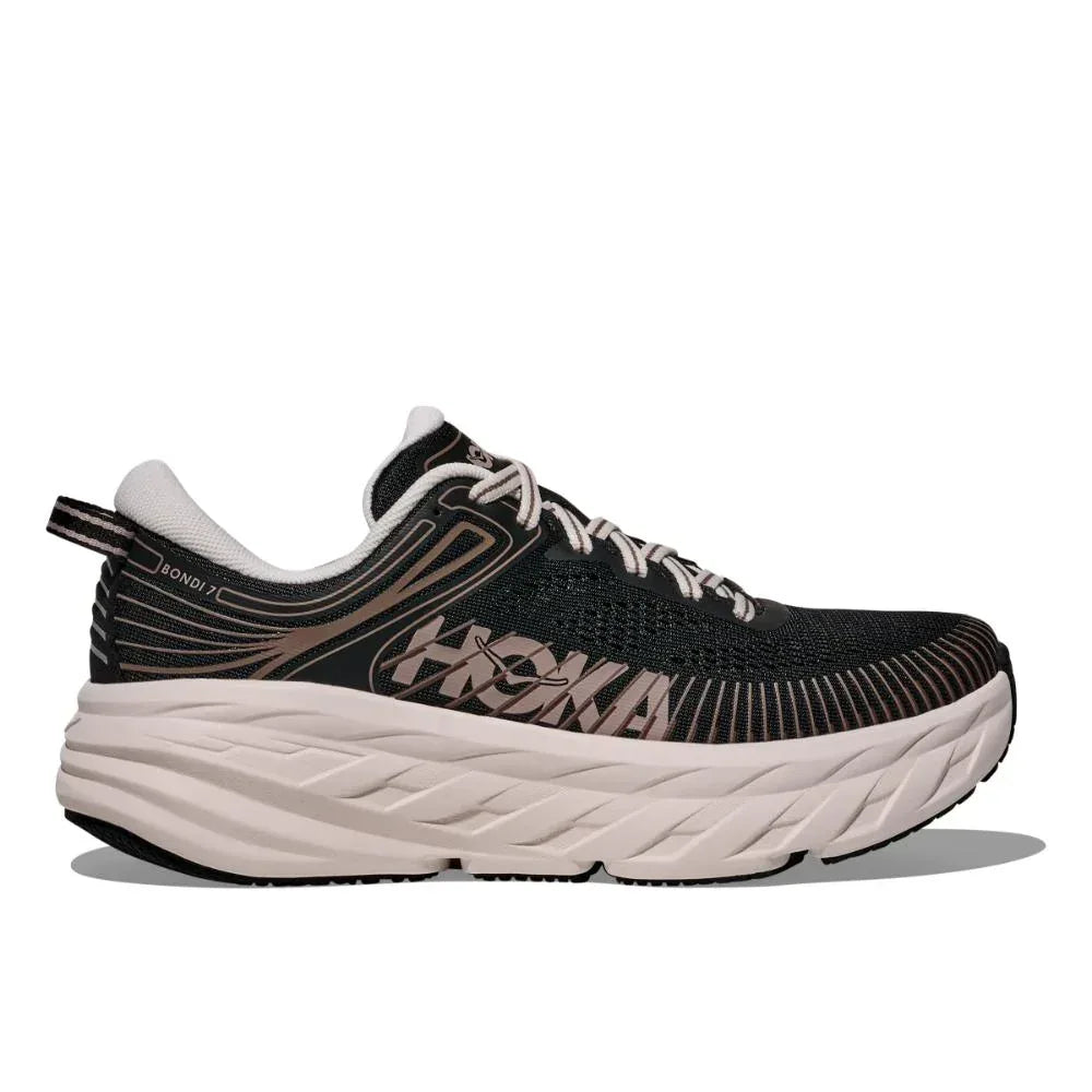 ה-Hoka BONDI 7 (1110519/BCKRS) בצבע שחור/ורוד קרם כולל גפה עליונה מרשת, סגירת שרוכים וסוליה לבנה עבה, מוצג בפרופיל צדדי על רקע לבן.