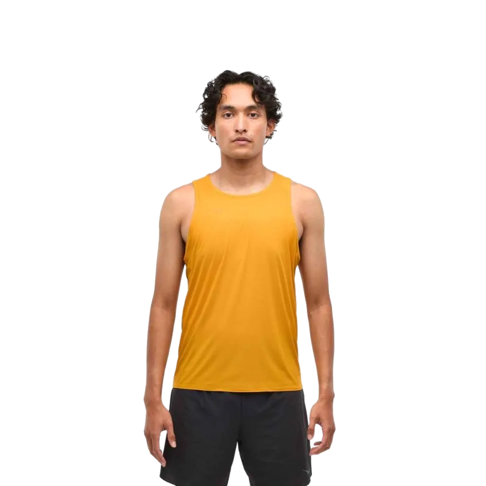 אדם עומד עם הפנים קדימה, לבוש בחולצת ריצה Hoka 1151070/VRST M Airolite Run Tank בצבע צהוב "Varsity Yellow" על רקע לבן פשוט.