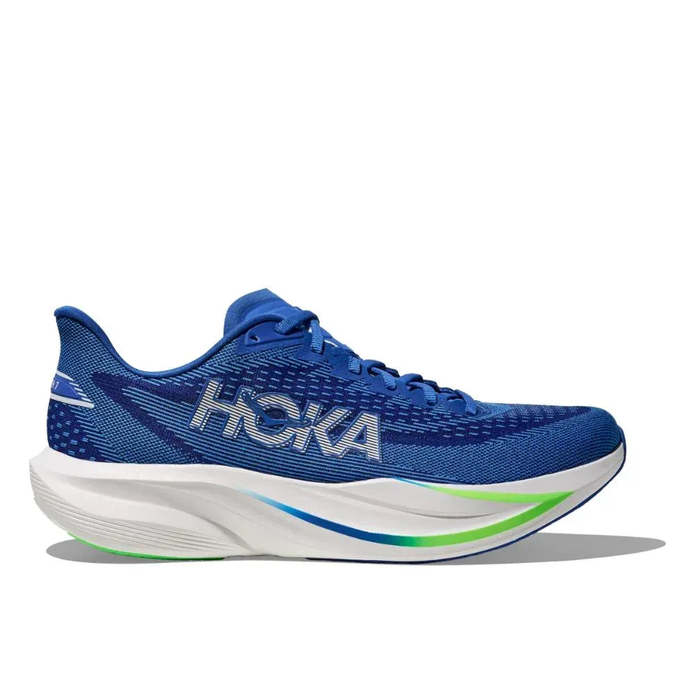 דגם Hoka MACH 7 (1171904/CBLTB) בצבעי כחול קובלט וניאון כולל סוליה לבנה מרופדת, נגיעות ירוקות ולוגו "HOKA" בולט בצד, המוצג על רקע לבן חלק.
