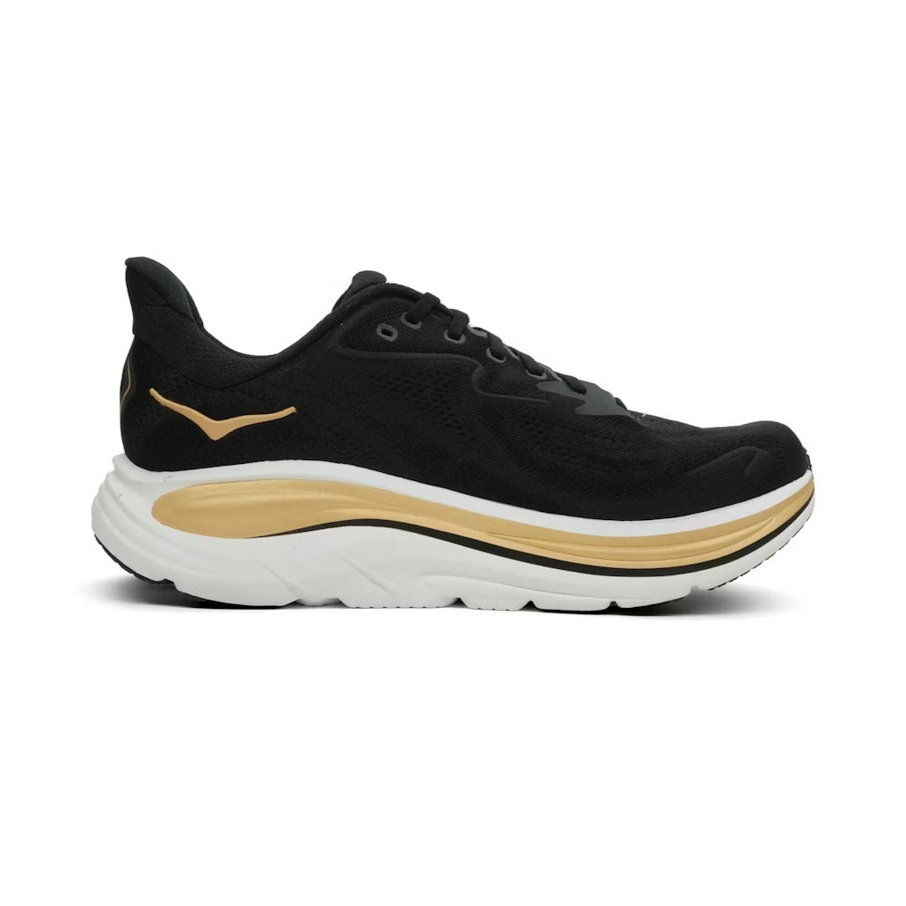 Hoka 1162030/BKGD CLIFTON 10 BLACK/GOLD הוא נעל ריצה אתלטית בצבע שחור מבית Hoka, עם נגיעות זהב, סוליה לבנה עבה וחלק עליון מרשת, המוצגת בתצוגה פרופילית.