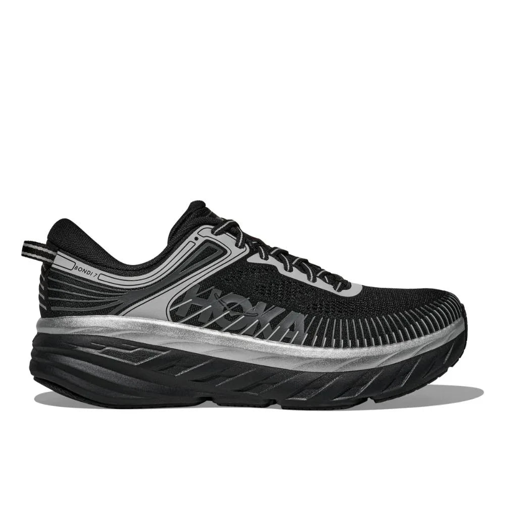 ה-Hoka 1110518/BKSTR BONDI 7 בצבע שחור/סטארדאסט הוא נעל ריצה ספורטיבית מבית Hoka, עם גפה עליונה מרשת בצבעי שחור ואפור, סוליה מרופדת ועבה ופרופיל צדדי.