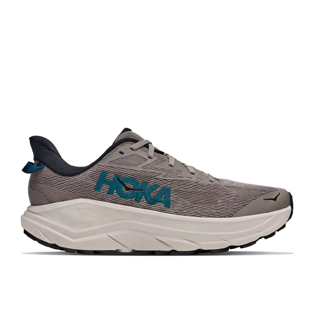 נעלי הריצה בשטח Hoka CHALLENGER 8 לגברים (דגם 1168716/PRYR, בצבע Pebble Grey/River) מוצגות בתמונת פרופיל צדדי על רקע לבן, עם לוגו טורקיז בולט, סוליה עבה ולבנה מרופדת לנוחות מירבית, סוליית חוץ שחורה ונגיעות בגוון אפור כהה—דגם זה של הוקה מציע שילוב של מהירות ועמידות כאופציה רב-תכליתית לריצה מהכביש לשטח.