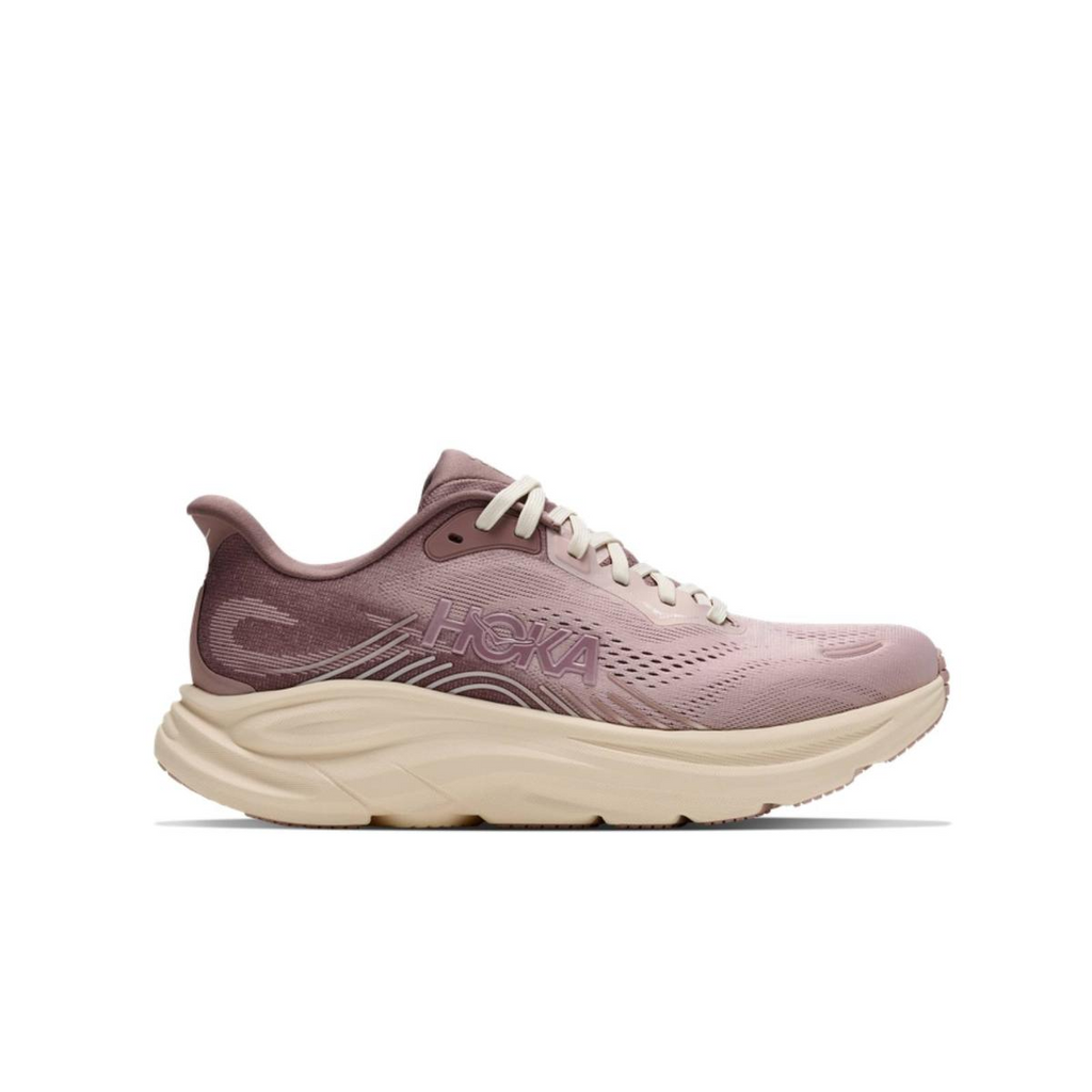 נעלי ריצה Hoka לנשים, דגם Hoka CLIFTON 11 GLM 1179199/PQR בצבע ורוד-בז', עם סוליה עבה, לוגו בצד ועליונה מרשת. אידיאלי לריצות נשים, מוצג בפרופיל על רקע לבן.
