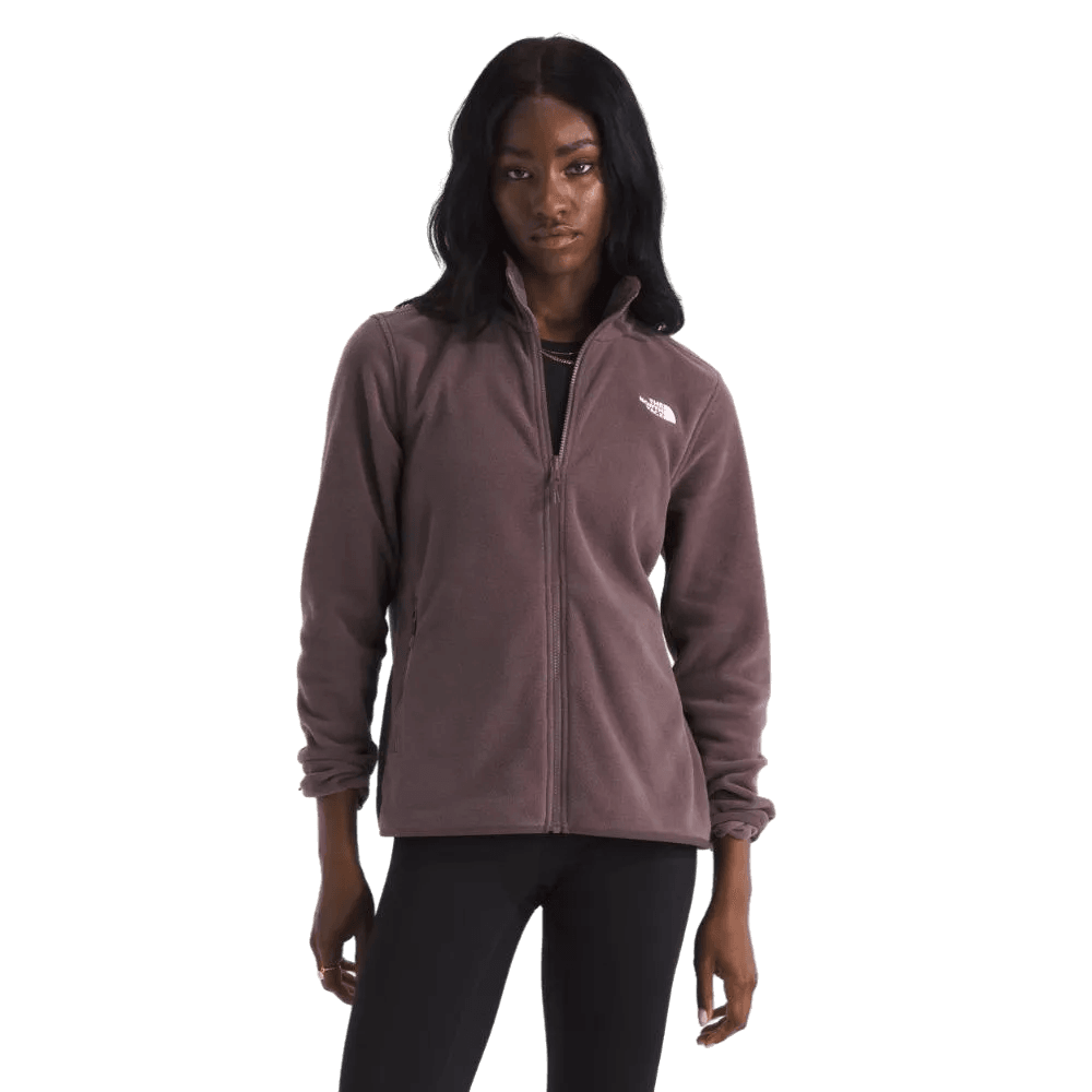אישה לבושה במעיל סגול של The North Face ג'קט פליס לנשים TNF GLACIER FLEECE JACKET TA8D2FBQ7 ומכנסיים שחורים עומדת על רקע לבן חלק.