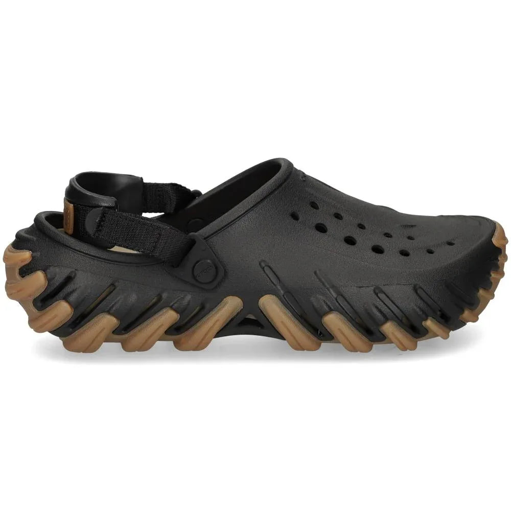 ה-Crocs Echo Gum RO Clog 211675-001 מבית Crocs הוא נעל סליפ-און שחורה עם חורי אוורור, רצועה אחורית וסוליה חומה עבה עם פרופיל.