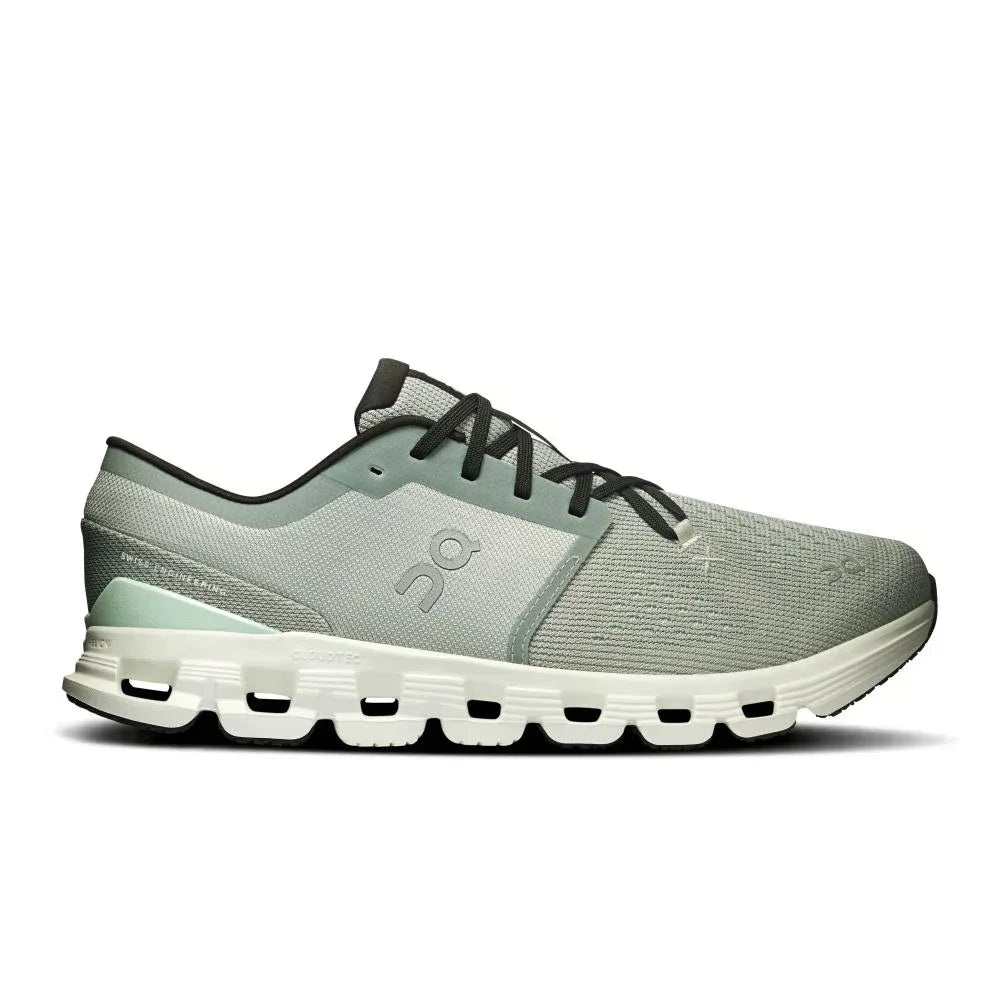 מבט צדדי על נעל הריצה On Cloud X 4 Tin/Iceberg מבית On Cloud, עם גפה עליונה מבד רשת נושם בצבעי אפור בהיר ולבן, שרוכים שחורים ועיצוב סוליה ייחודי ומחולק.