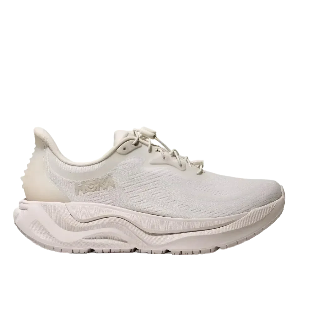 מבט צדדי על נעל הריצה Hoka ARAHI SR 1168713/WWH WHITE, עם סוליה מרקמת, חלק עליון מרשת וסימן לוגו Hoka עדין על רקע חלק.