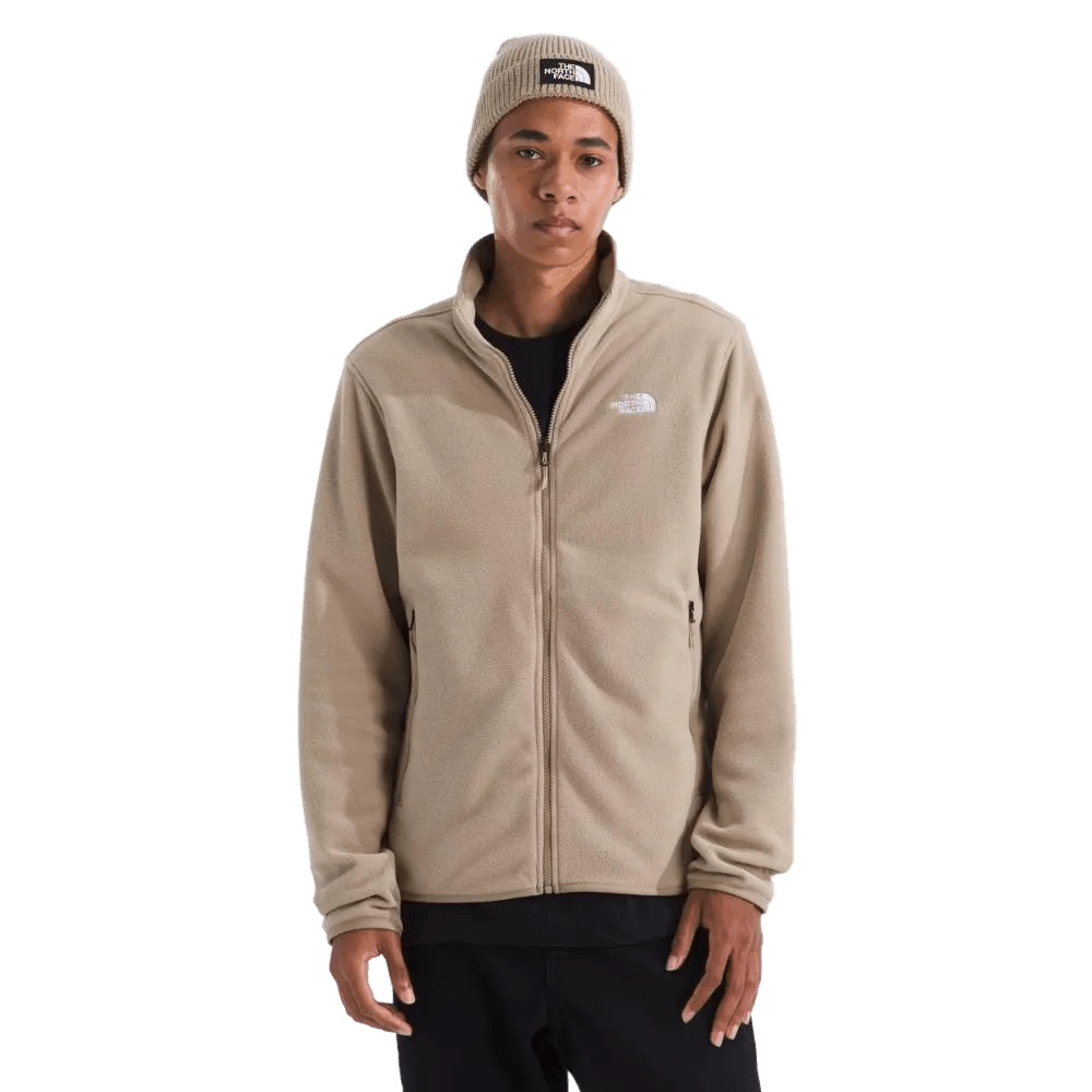 גבר לובש ג'קט פליס לגברים GLACIER FLEECE JACKET TA8D0RBOX של The North Face בצבע בז' עם כובע צמר תואם עם לוגו, עומד על רקע לבן חלק.
