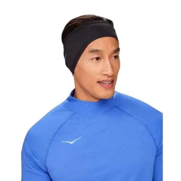 יחיד בחולצה ספורטיבית כחולה וסרט Hoka 1147315/BLK Run Fleece בשחור, מבט הצידה.