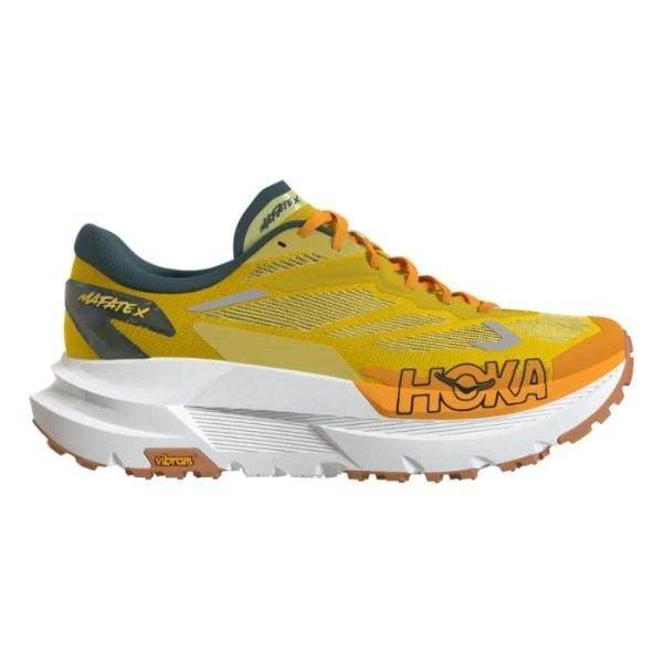 נעלי ריצה Hoka 1161990/ZTM MAFATE X ZEST/MOUNTAIN FOG הן נעלי ריצה צהובות וכתומות עם סוליה לבנה עבה, שרוכים כתומים ולוגו HOKA בצד.