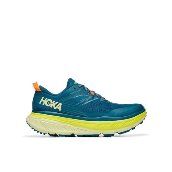 נעל ריצה כחולה וצהובה של Hoka Stinson 6, מוצגת מהצד, עם סוליה עבה מרופדת ולוגו בולט.
