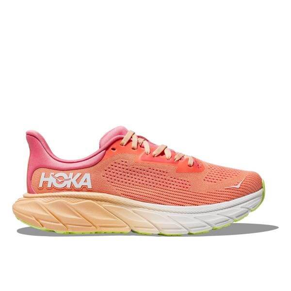 מבט מהצד של נעל הריצה Hoka 1147890/PPCY W ARAHI 7 WIDE (D) בצבע קורל, הכוללת סוליה עבה, מיתוג לבן והדגשות ירוקות בסוליה החיצונית.