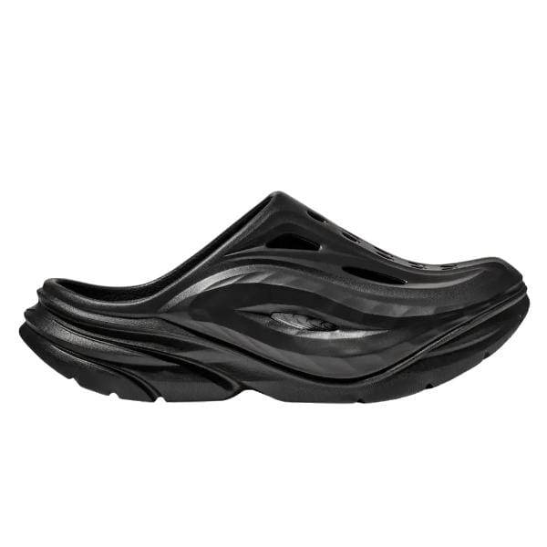 Hoka ORA RECOVERY MULE 1147951/BBLC מבית Hoka הוא סנדל החלקה שחור בעיצוב גלי, הכולל חורי אוורור וסוליה עבה עם קווי מתאר.