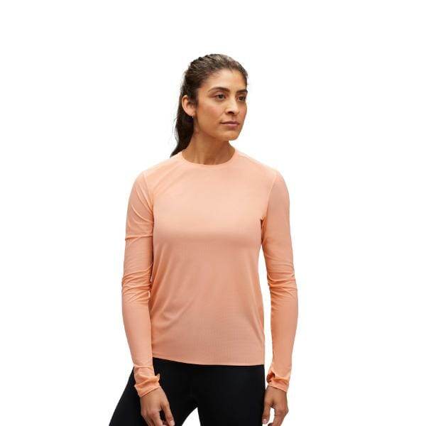 אדם שלובש חולצת Hoka 1151083/PAY W AIROLITE RUN LONG SleeVE במכנסיים אפרסק ושחורים עומד על רקע לבן.