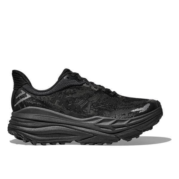 מבט צדדי של Hoka 1141530/BBLC STINSON 7 BLACK מציג נעל אתלטית שחורה עם סוליה בעלת מרקם ועיצוב שרוכים.