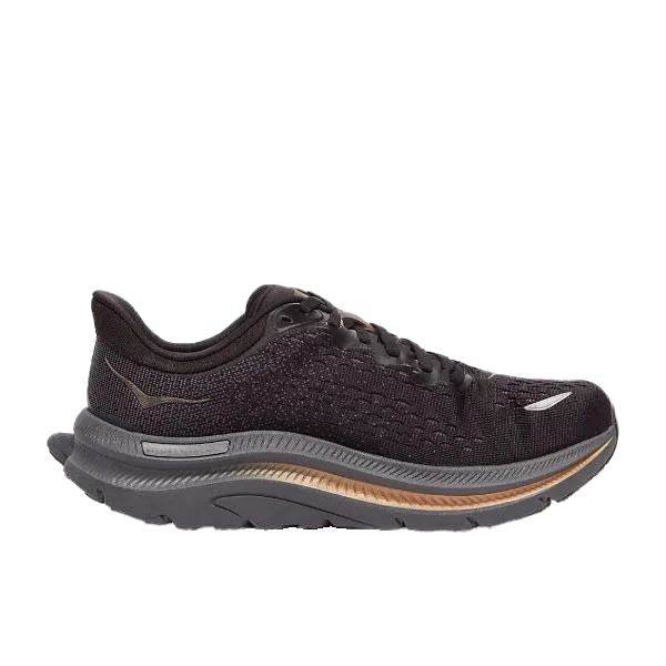 שחור Hoka Kawana 1123164/BCPPR עם סוליה עבה, אפורה וכתומה, שרוכים שחורים ופרטי לוגו לבן בצד ובבוהן. לנעל Hoka עיצוב עליון נושם ונראית מתאימה לריצה או הליכה.