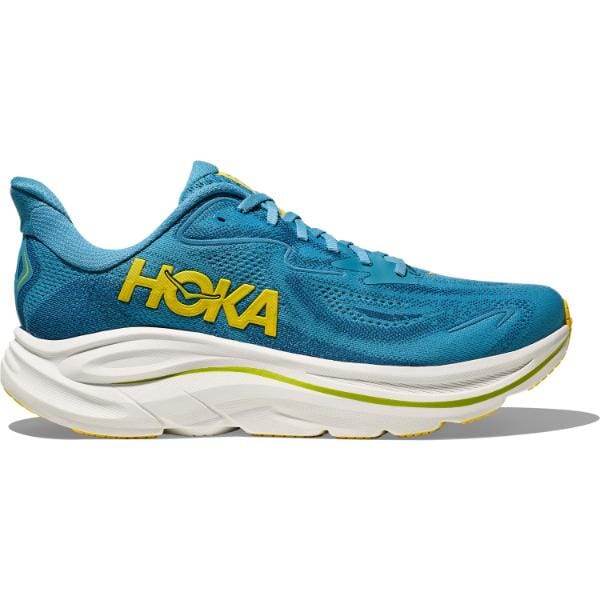 ה-Hoka 1162032/ALF CLIFTON 10 WIDE (2E) הוא נעל ריצה ספורטיבית בצבע כחול עם סוליה לבנה עבה ולוגו Hoka צהוב בצד.
