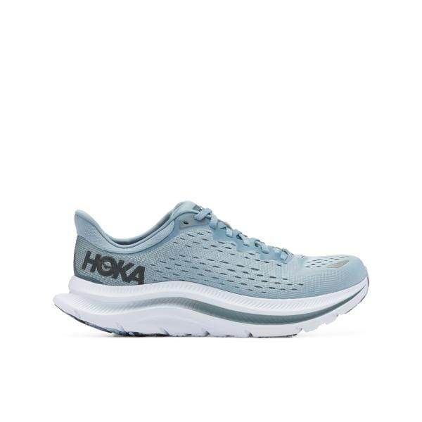 נעל ריצה Hoka Kawana 1123163/MSGB בצבע כחול בהיר עם סוליה לבנה והדגשים אפורים, במבט מהצד. המילה "HOKA" נראית על העקב.