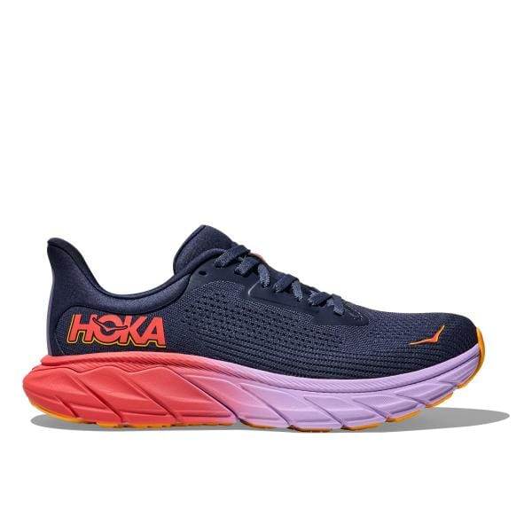 מבט מהצד של נעל הריצה Hoka 1147851/NKV ARAHI 7 המציגה חלק עליון כחול כהה עם לוגו אדום וסוליה צבעונית בשילוב כתום, סגול וצהוב.
