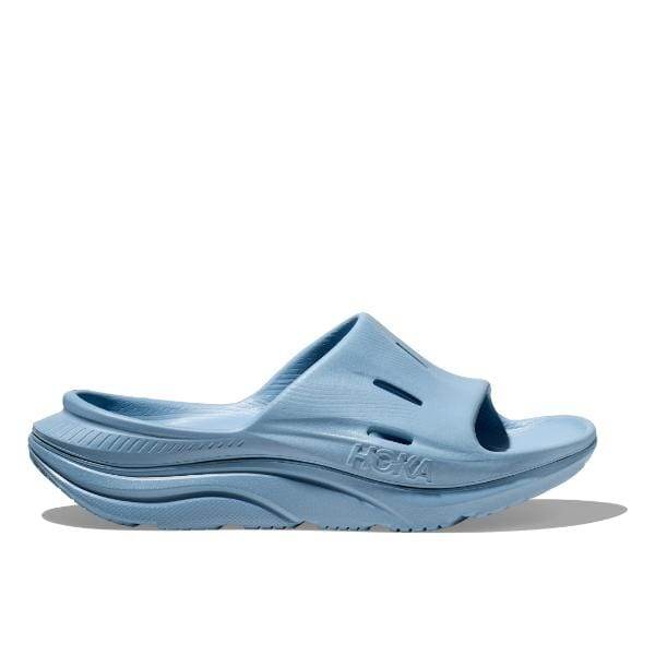 סנדל Hoka 1135061/DKD W ORA RECOVERY SLIDE 3 כחול בהיר עם בוהן פתוחה, סוליה עבה ועיצוב ארגונומי, ממוקם על רקע לבן.