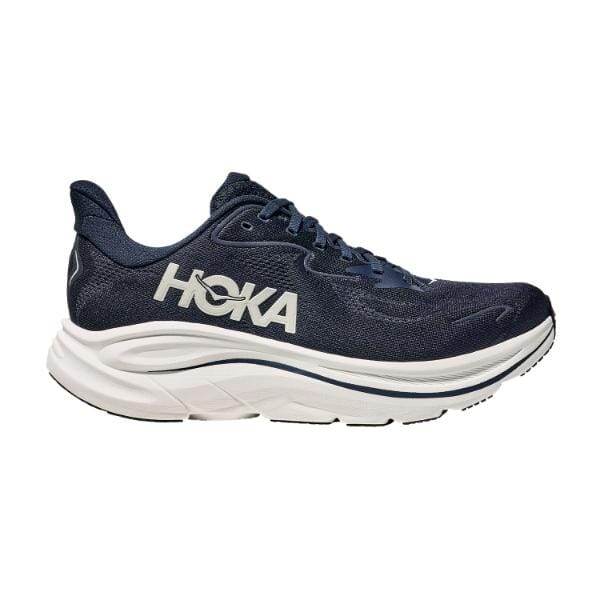 נעלי הריצה Hoka CLIFTON 10 WIDE (2E) 1162032/NWT NAVY הן נעלי ריצה בצבע כחול כהה של Hoka עם סוליה לבנה עבה ולוגו לבן, על רקע לבן חלק.