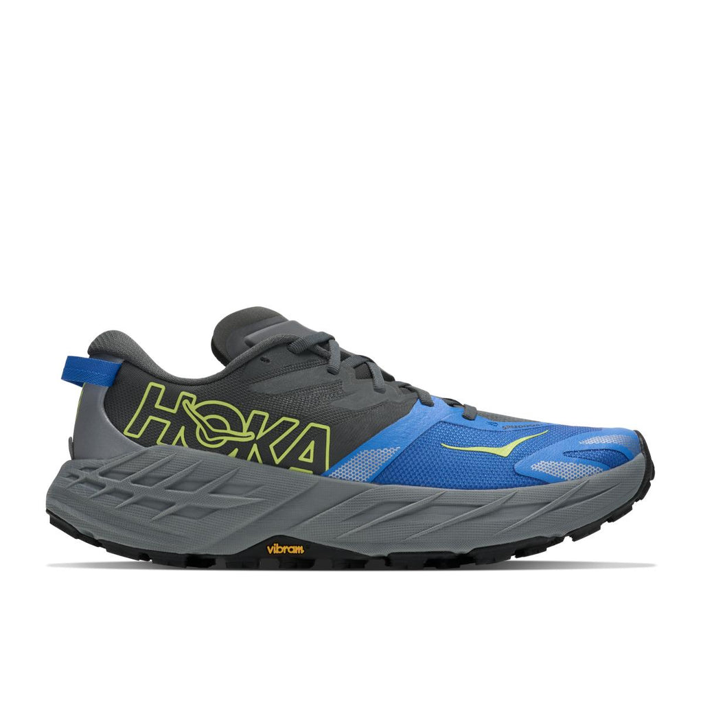 נעלי ריצת שטח Hoka Speedgoat 7 Wide (2E) לגברים בצבע Outer Orbit/Virtua – כחול, שחור ואפור עם נגיעות צהוב, על רקע לבן