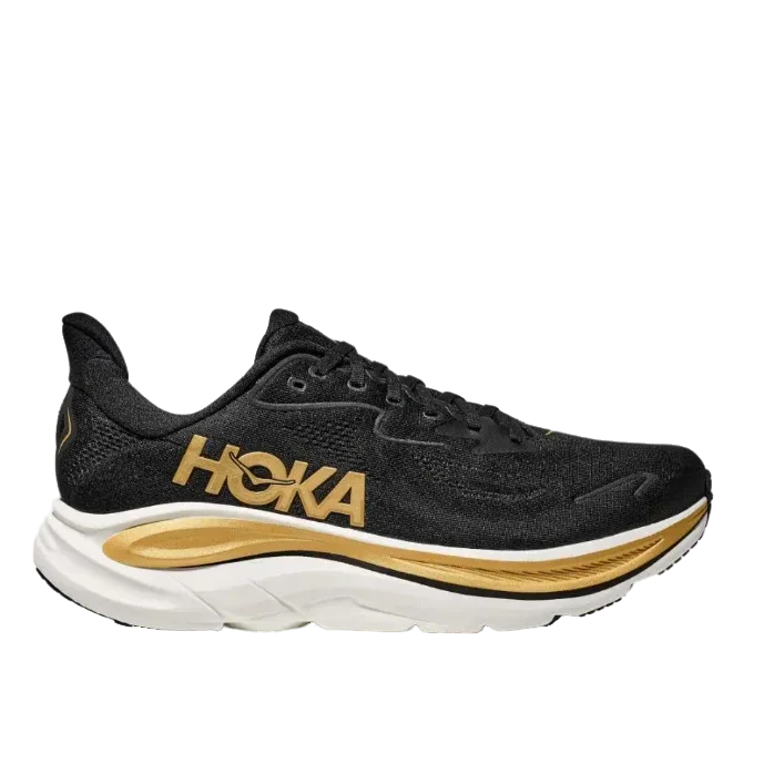נעלי הריצה הוקה קליפטון 10 Hoka 1162030/BKGD CLIFTON 10 מבית Hoka הן נעלי ריצה שחורות עם נגיעות זהב וסוליה לבנה, המוצגות בפרופיל צדדי על רקע לבן חלק.