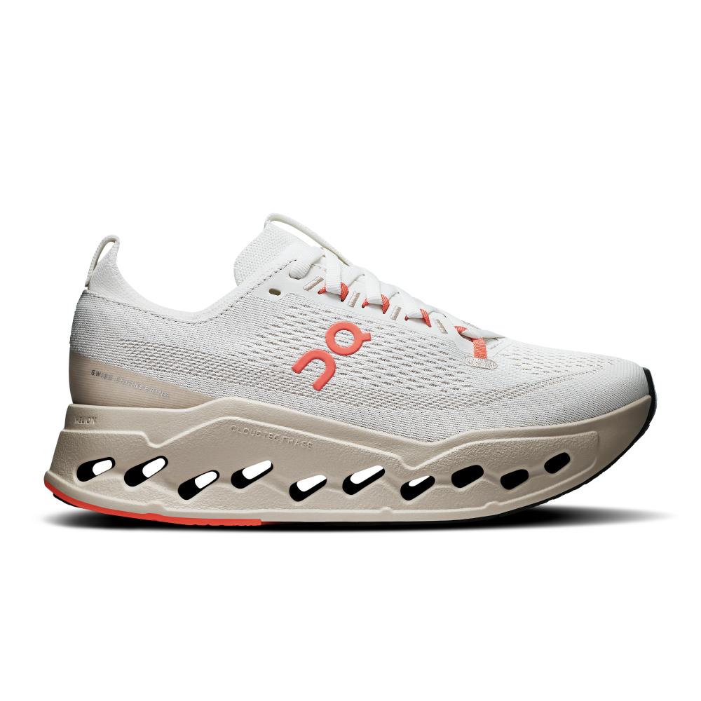 נעלי ריצה און קלאוד סארפר מקס לנשים On Cloudsurfer Max 3WF30223297 Ivory/Salmon משלבות עיצוב אופנתי עם ביצועים גבוהים, עם סוליה עבה בגוון בז', חיתוכי אובאלים, נגיעות אדום ורשת אוורירית ולוגו Cloudsurfer Max אדום בצד.