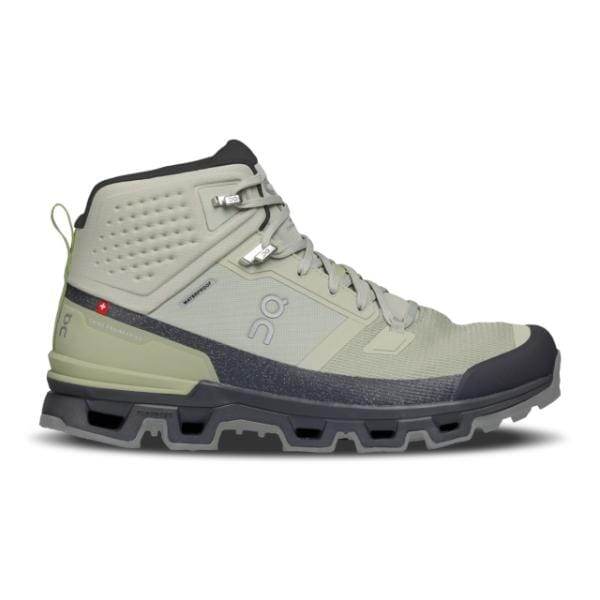ה-On Cloudrock 2 Waterproof Chalk/Eclipse של On Cloud כולל מגף הליכה יחיד בגובה בינוני בצבע אפור בהיר עם סוליה שחורה עבה, שרוכים מלפנים ולולאה קטנה מאחור.
